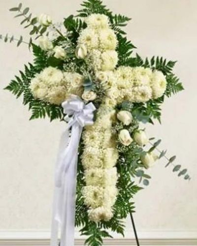 Send a beautiful and striking floral tribute that shows your support and love during this difficult time. This standing spray arrangement in the shape of a cross is created from fresh white roses, football mums, greenery and floral accents. Traditionally sent directly to the funeral home by family members or friends and displayed on a stand.