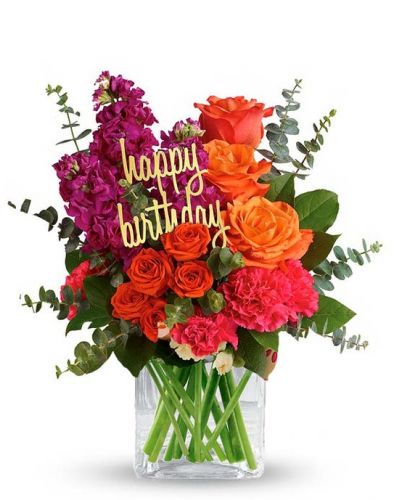 Fill someone's birthday with color! This brightly colored birthday flower bouquet is created with mixed floral stems including orange roses, pink carnations and orange spray roses. All the beautiful flowers are hand arranged by a florist near you in a glass cube vase. Note: Happy Birthday pick may vary depending on local florist's availability.