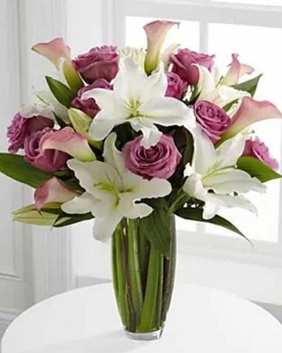 Flowing with unparalleled elegance, this fresh from the farm bouquet offers blooming beauty in soft shades of pink, lavender and white. Brilliant white Oriental Lilies stretch their long star-shaped petals across a bed of pink miniature calla lilies and 20-inch lavender roses all accented with vibrant, lush greens. Seated in a superior clear glass vase, this bouquet is a wonderful way to commemorate a special moment.