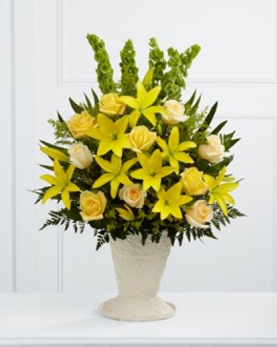<p>The FTD® Golden Memories™ Arrangement bursts with sunlit beauty to honor the life of the deceased. Brilliant yellow Asiatic lilies, roses and solidago are offset by cream roses, Bells of Ireland, teepee palm fronds and lush greens to create a dazzling display. Arranged in a large papier mache urn, this incredible presentation of floral grace will bring a cheerful elegance to their final farewell service.</p>