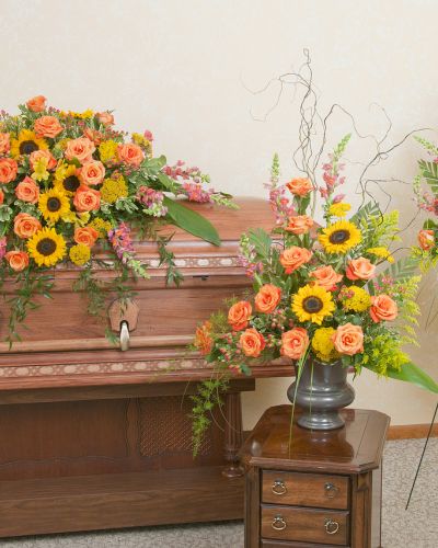 Includes a casket spray, standing spray and urn design in the warm colors of a sunset.
